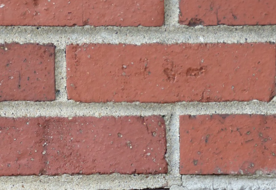 Raked-out mortar joints on a brick wall ready for repointing